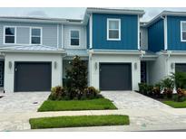 Charming townhomes boast modern design, gray accents, and well-manicured landscaping at 7773 Spectrum Dr, Reunion, FL 34747