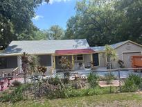 Charming single-story home featuring colorful landscaping and a unique red tile roof accent at 822 5Th St, Orlando, FL 32824