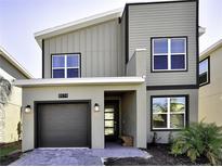 Contemporary two-story home with a modern design, featuring a gray exterior, clean lines, and a single-car garage at 8974 Cabot Cliffs Dr, Davenport, FL 33896