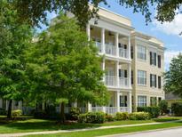Elegant three-story building with balconies and lush green landscaping, offering a serene residential setting at 920 Spring Park St # 301, Celebration, FL 34747