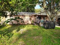 Cozy home with front yard featuring a large tree, green grass, and outdoor cooking area at 154 Avalon Rd, Winter Garden, FL 34787