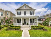 Charming two-story home with landscaped yard, covered front porch, and beautiful curb appeal at 2108 Celebration Blvd, Celebration, FL 34747