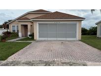 Charming one-story home featuring a screened garage and brick-paved driveway at 2646 Quarterdeck Ct, Kissimmee, FL 34743