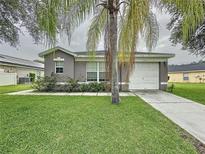 Charming single-story home with well-maintained lawn and mature palm tree in a quiet neighborhood at 350 Scrub Jay Way, Davenport, FL 33896