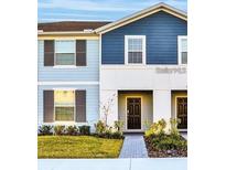 Inviting townhome featuring a well-manicured lawn, neutral siding, and charming double door entry at 3878 Lana Ave, Davenport, FL 33897