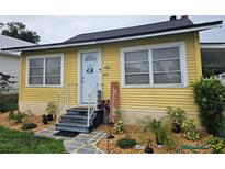Charming home with a yellow exterior, well-maintained front yard, and inviting entryway with a welcome sign at 419 Ohio Ave, St Cloud, FL 34769