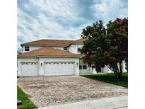 Charming two-story home with a three car garage and a brick driveway with a beautiful lawn and landscaping at 4368 Fox Glen Loop, Kissimmee, FL 34746