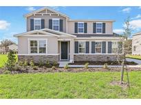 Charming two-story home featuring a stone veneer, neutral colors, and well-maintained landscaping at 530 Summit River Dr, Apopka, FL 32712