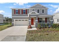 Charming two-story home featuring a red front door, stone accents, neutral siding, and a well-manicured lawn at 540 Summit River Dr, Apopka, FL 32712