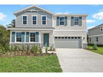Charming two-story home with light blue and white siding, shutters, stone accents, and a well-manicured lawn at 565 Summit River Dr, Apopka, FL 32712