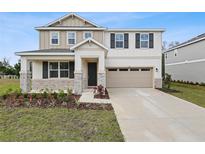 Charming two-story home with stone accents, a two-car garage, and a well-manicured front yard at 630 Summit River Dr, Apopka, FL 32712
