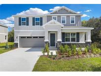 Charming two-story home with a well-manicured lawn and stylish gray color scheme at 645 Summit River Dr, Apopka, FL 32712