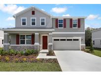Charming two-story home with a well-manicured lawn and a two-car garage with red shutters at 655 Summit River Dr, Apopka, FL 32712