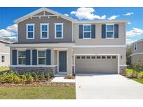 Charming two-story home features a two-car garage, stone accents, neutral colors, and a well-maintained front yard at 665 Summit River Dr, Apopka, FL 32712