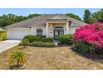 Charming single-story home with lush landscaping and bright pink bougainvillea in the front yard at 116 Westport Ln, Davenport, FL 33896