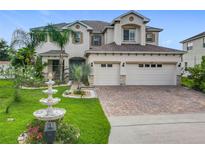 Beautiful two-story home with a well-manicured lawn, water fountain, and a three-car garage at 16072 Shasta St, Clermont, FL 34714