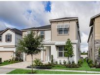 Charming two-story home features a combination of stucco and siding, complemented by green grass and trees at 1810 Caribbean View Ter, Kissimmee, FL 34747