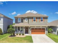 Charming two-story home with a well-manicured lawn, inviting front porch, and a convenient two-car garage at 1856 Castleton Dr, St Cloud, FL 34771
