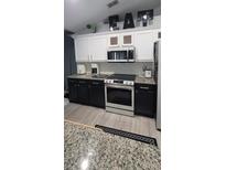Modern kitchen featuring stainless steel appliances and granite countertops at 1913 Manatee Ct, Kissimmee, FL 34759