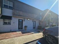 Townhouse exterior features well-maintained stucco, covered entries and tidy brick and concrete walkways at 1920 Conway Rd # 4, Orlando, FL 32812