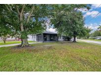 Charming single-story home with large trees, a screened porch and well-manicured lawn on a corner lot at 2 S Lavon Ave, Kissimmee, FL 34741