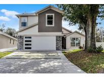 Charming two-story home featuring a clean two-car garage and modern stone accents at 2561 Montego Bay Blvd, Kissimmee, FL 34746