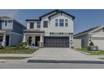Charming two-story home featuring a two-car garage, stylish shutters, and manicured landscaping at 466 Cool Summer Ln, Davenport, FL 33837
