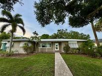 Charming single-story home with a well-maintained lawn, mature trees, and a brick walkway leading to the front door at 612 Lakeshore Blvd, Kissimmee, FL 34744