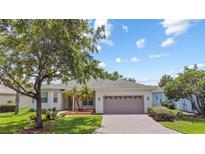 Charming single-story home with a well-manicured lawn, a brick driveway, and a two-car garage at 759 Largo Pass, Poinciana, FL 34759