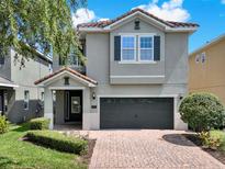 Charming two-story home features a brick driveway, well-manicured lawn, and a neutral-colored exterior at 7613 Brookhurst Ln, Kissimmee, FL 34747