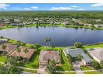 Stunning aerial view of home with lake frontage and lush green landscape; wooded area in the distance at 777 Glendora Road, Poinciana, FL 34759