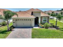 Charming single-story home with a tile roof, brick-paved driveway, and well-manicured landscaping at 1101 Downswing Pl, Davenport, FL 33896
