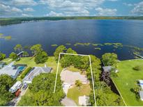 Expansive aerial view of the lakefront home with lush greenery and stunning lake views at 1186 Laguna Cir, St Cloud, FL 34771