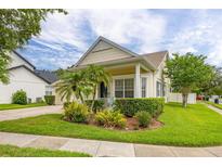 Charming home with manicured lawn, lush landscaping, and a welcoming front porch at 14167 Bradbury Rd, Orlando, FL 32828