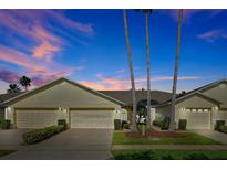 Charming one-story home with well-manicured lawn and three palm trees providing a pleasant, tropical feel at 168 Club Villas Ln, Kissimmee, FL 34744