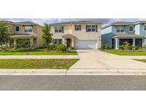 Two-story home featuring a well-manicured lawn, a two-car garage, and neutral colored paint at 176 Sofia Ln, Lake Alfred, FL 33850