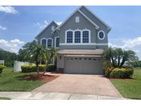 Charming two-story home with a brick driveway and well-maintained landscaping and a gray two-car garage at 2255 Stone Lake Ct, Orlando, FL 32824