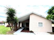 Cozy single-story home featuring a charming front yard with mature trees and a covered entrance at 3 Trophy Ln, Kissimmee, FL 34759