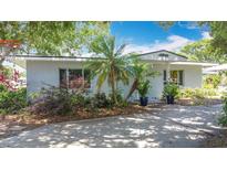Charming, painted brick home with a well-manicured, partially shaded front yard with palm trees at 301 Oregon Ave, St Cloud, FL 34769