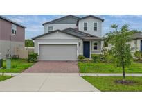 Charming two-story home with a brick driveway, attached two car garage, and well-manicured lawn at 5288 Stephs Field St, St Cloud, FL 34771
