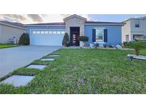 Charming single-story home with well-manicured lawn and stone accents at 585 Lucerne Blvd, Winter Haven, FL 33881