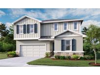 Charming two-story home with blue shutters, stone accents, landscaped yard, and an attached two-car garage at 6167 Daphne St, Lake Hamilton, FL 33851