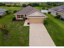 Charming single-story home featuring a well-manicured lawn and an attached two-car garage at 1158 Legatto Loop, Dundee, FL 33838