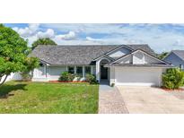 Charming single-story home features a well-manicured lawn, brick walkway, and a two-car garage at 121 White Birch Dr, Kissimmee, FL 34743