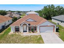 Charming single-story home featuring a symmetrical facade, arched windows, and a well-manicured lawn at 1912 Manatee Ln, Poinciana, FL 34759