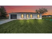 Charming single-story home featuring a modern design, fresh landscaping, and a gray painted garage at 2 Dogwood Radl, Ocala, FL 34472