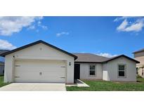 Charming single Gathering home showcasing a two car garage, well manicured lawn and beautiful blue skies at 2309 Rio Grande Forest Ln, Kissimmee, FL 34759