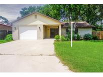 Charming single-story home with a brick facade, attached garage, and a well-maintained lawn at 3 Rosewood Dr, Davenport, FL 33837