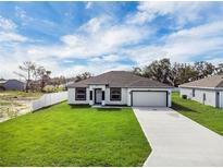 Charming single-story home with a well-manicured lawn, long driveway and attached garage at 4613 Madison Ave, Lake Wales, FL 33859