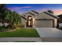 Charming home featuring a manicured lawn, arched entry, and a two-car garage at 7922 Elmstone Cir, Orlando, FL 32822